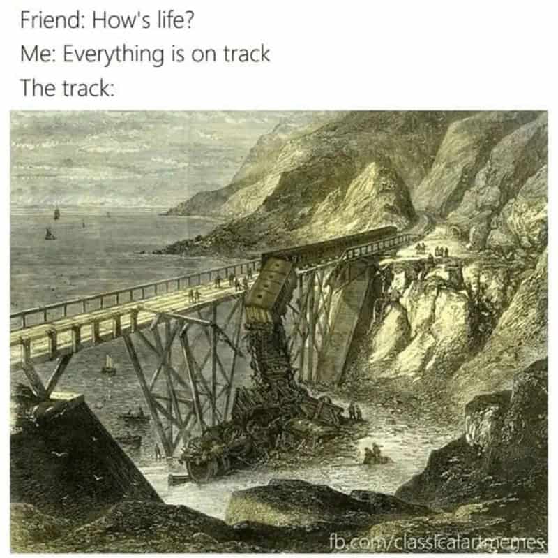 Train derails on a bridge with a mountain landscape in the background.