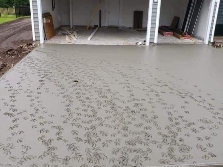 Concrete driveway with footprints in front of a garage under construction.