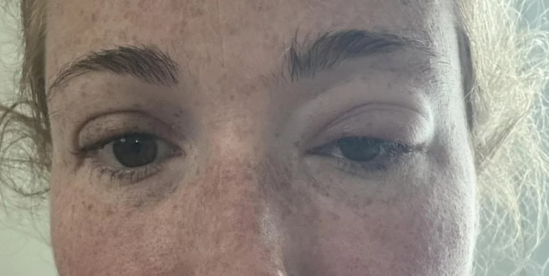 Close-up of a person's face with one eye open and the other partially closed.