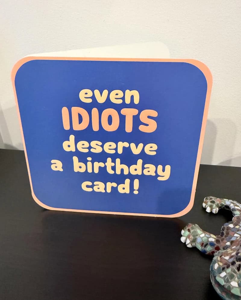 Colorful birthday card with the text 'even IDIOTS deserve a birthday card!'.