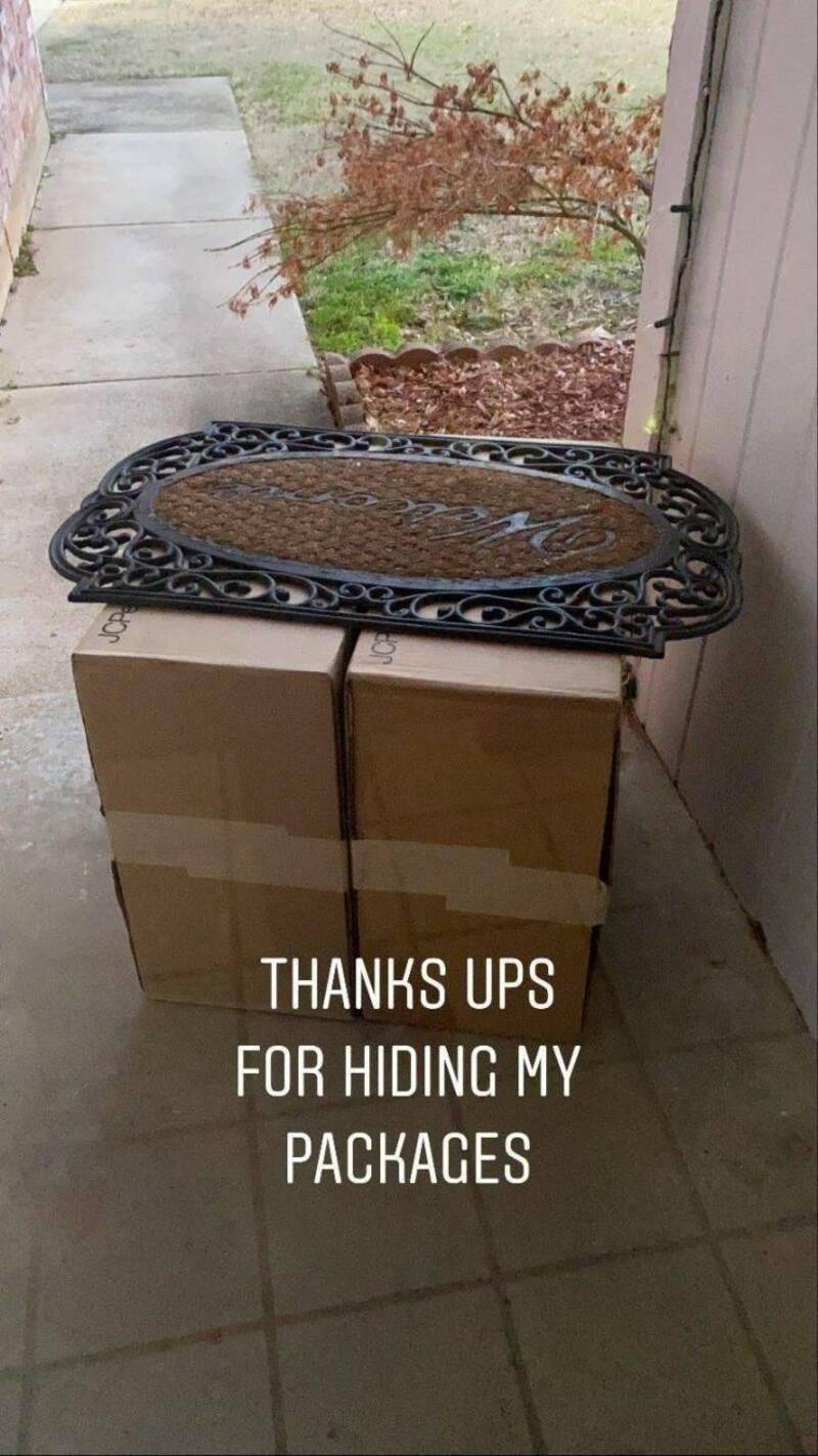 A decorative black metal tray on top of two cardboard boxes outside a door.