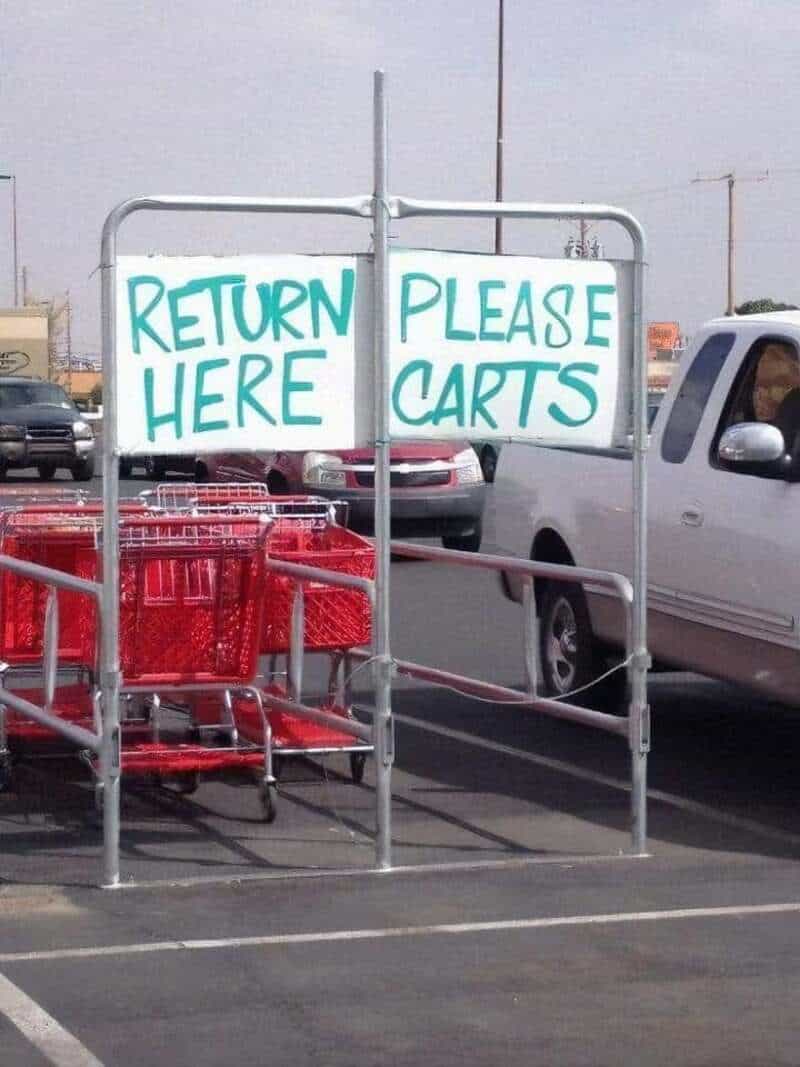 Return here please carts sign in parking lot with shopping carts.
