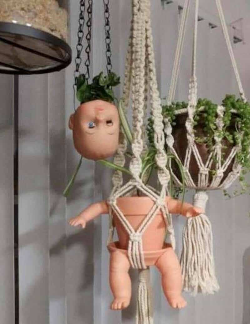 Baby doll hanging with plants and macrame planters, funny decor.