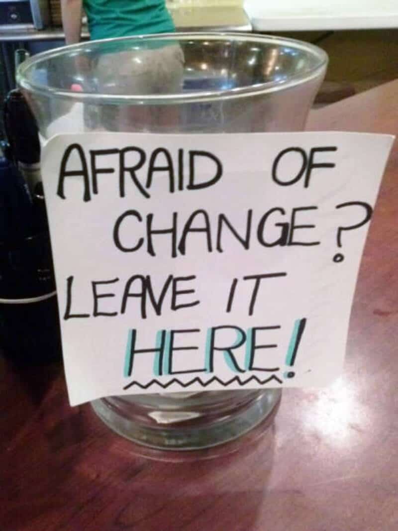 Sign in a glass bowl says 'AFRAID OF CHANGE? LEAVE IT HERE!'.