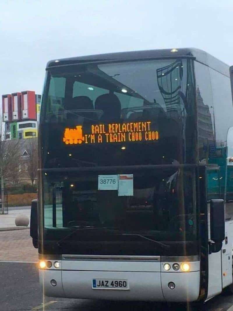 Digital sign on bus reads 'RAIL REPLACEMENT I'M A TRAIN CHOO CHOO' with pixelated train icon.