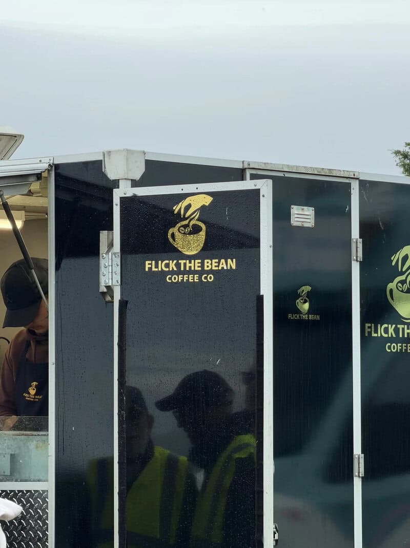 Flick the Bean Coffee Co food truck with a snake logo and people in yellow vests.