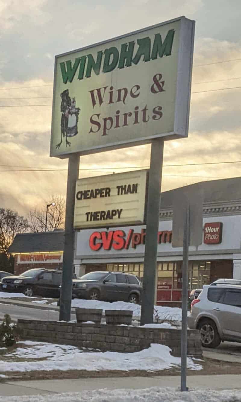 Sign for Windham Wine & Spirits with a humorous sign below.