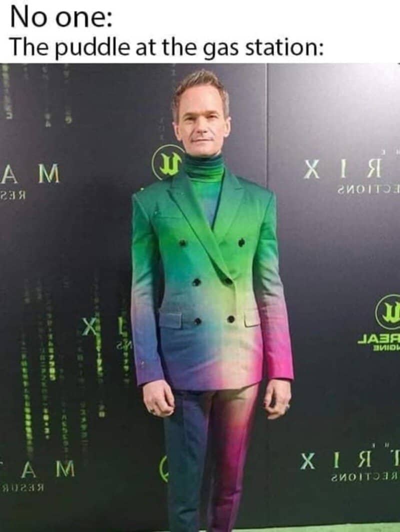 Man in a rainbow-colored suit at gas station with no one around.