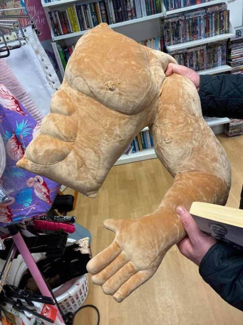 Large plush hand and foot costume parts held by people in a store.