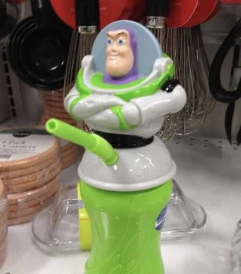Buzz Lightyear figurine with arms crossed, in a store aisle.
