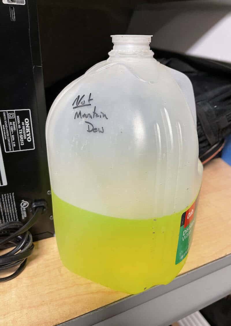 A plastic bottle with a yellow-green liquid and handwritten label 'Not Mountain Dew'.