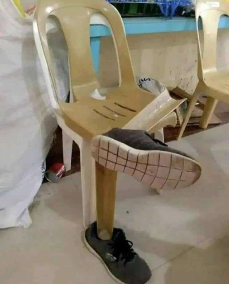 Chair with a shoe attached to the leg, creating the illusion of a foot.