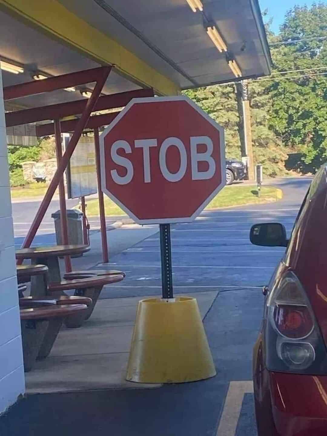 Stop sign with misspelled 'STOB' on a traffic cone base.