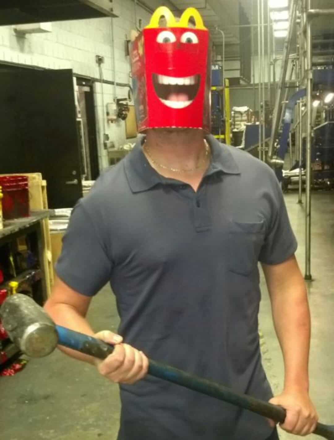 Person with a McDonald's box on their head with a smiling face and yellow arches.