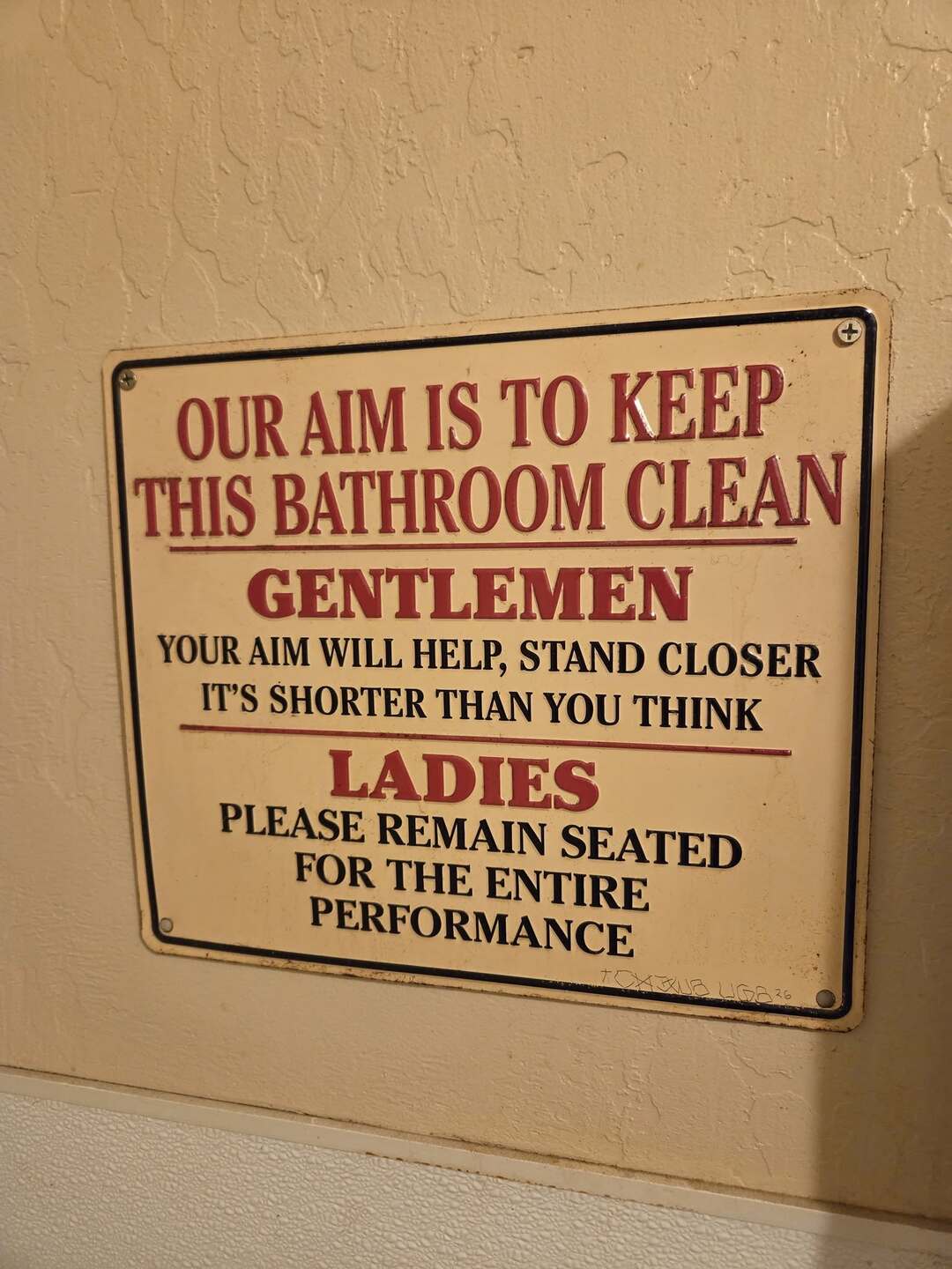 Sign with humorous bathroom rules for gentlemen and ladies.