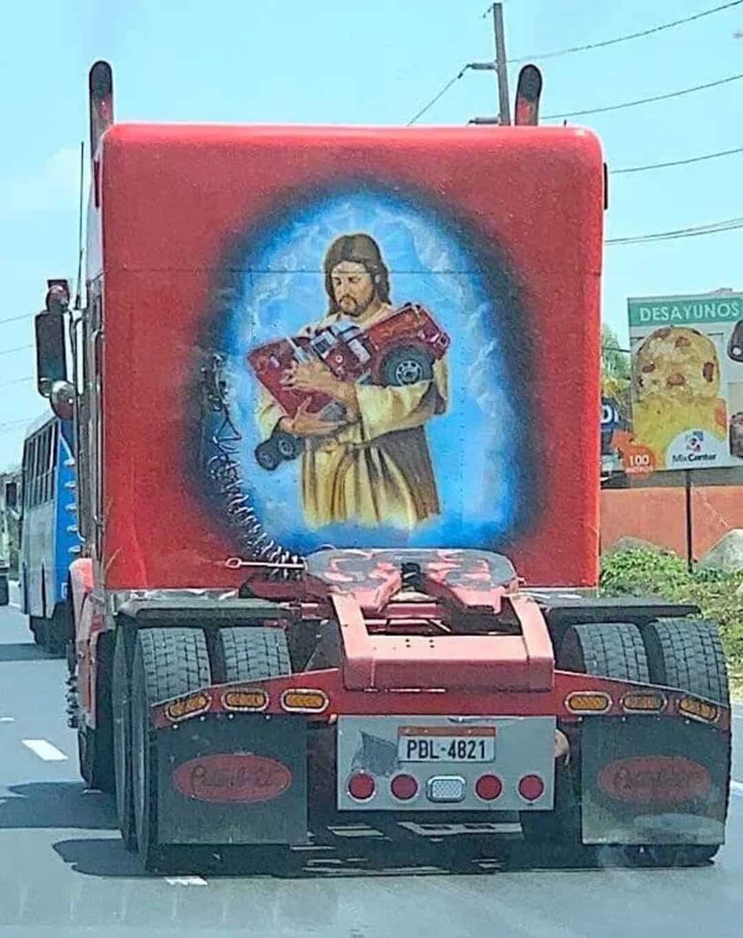 Truck with religious image of Jesus holding a guitar and a book painted on the back.