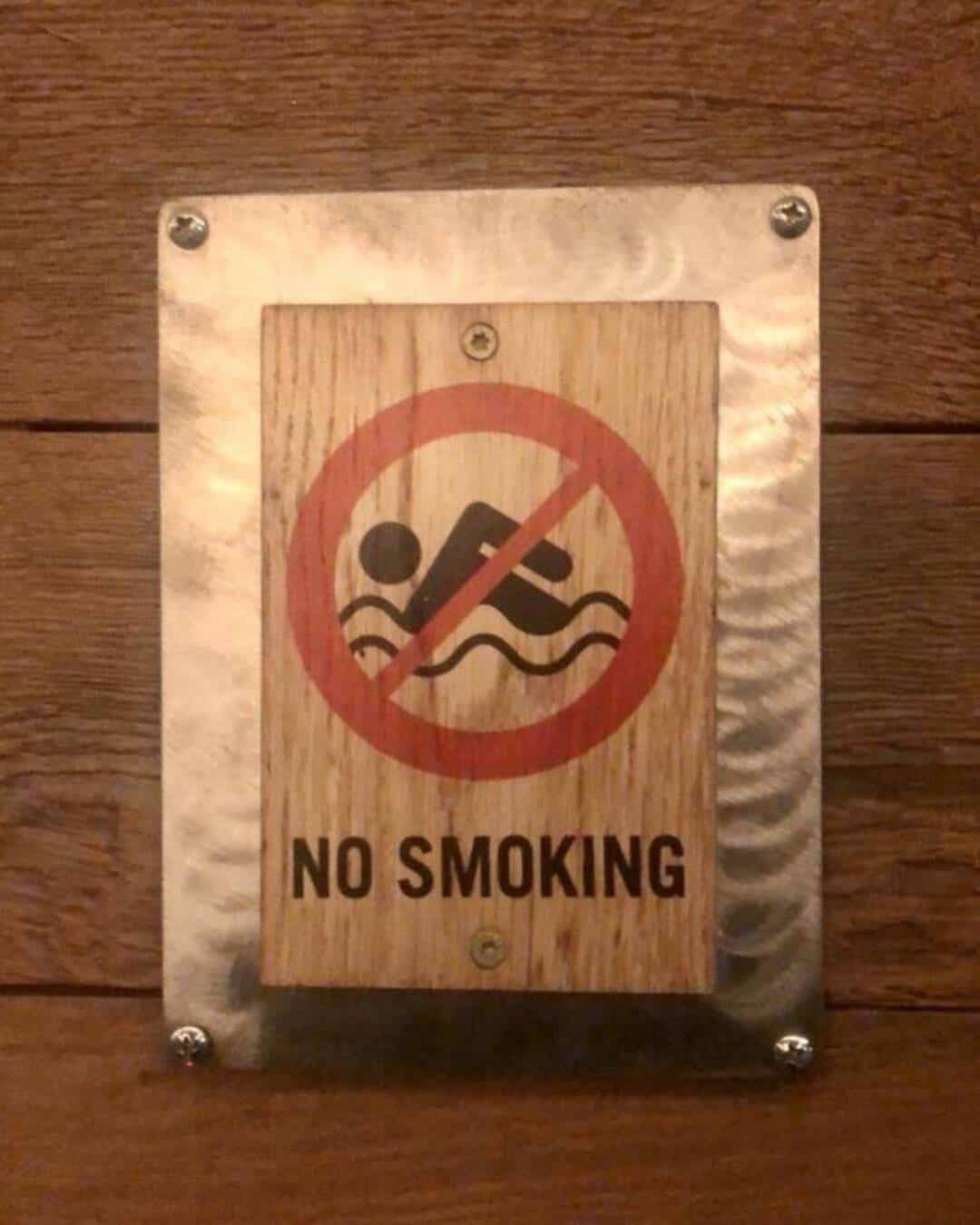 No smoking sign with a swimmer icon crossed out.