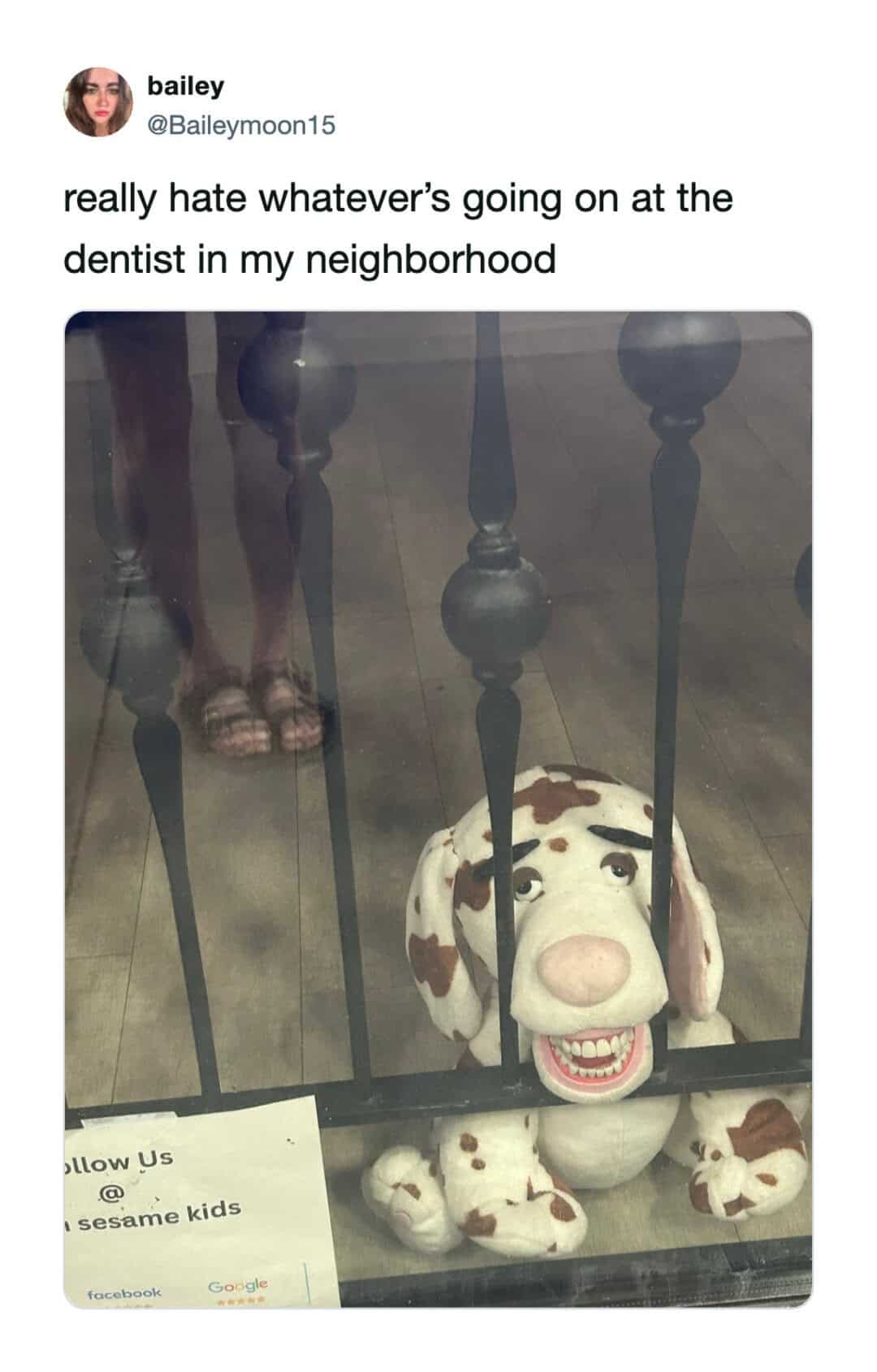 Dog plush toy behind a gate with a real person's legs visible above.