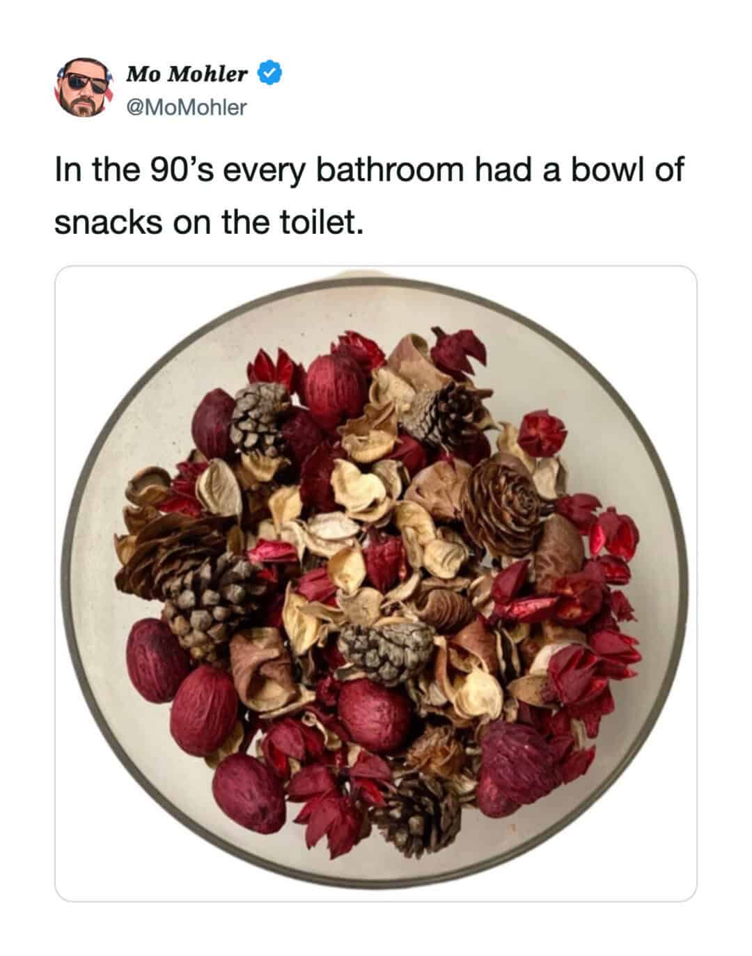 Bowl of snacks on the toilet with dried flowers and pinecones.