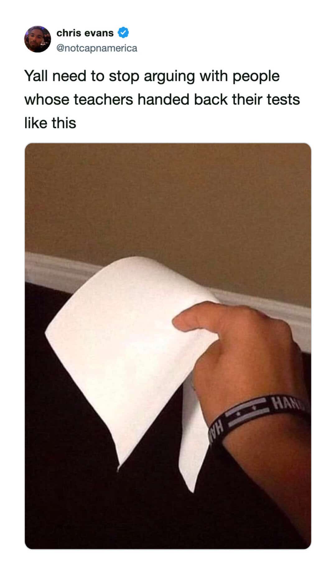 Person holding a torn piece of paper with a humorous caption about teachers.