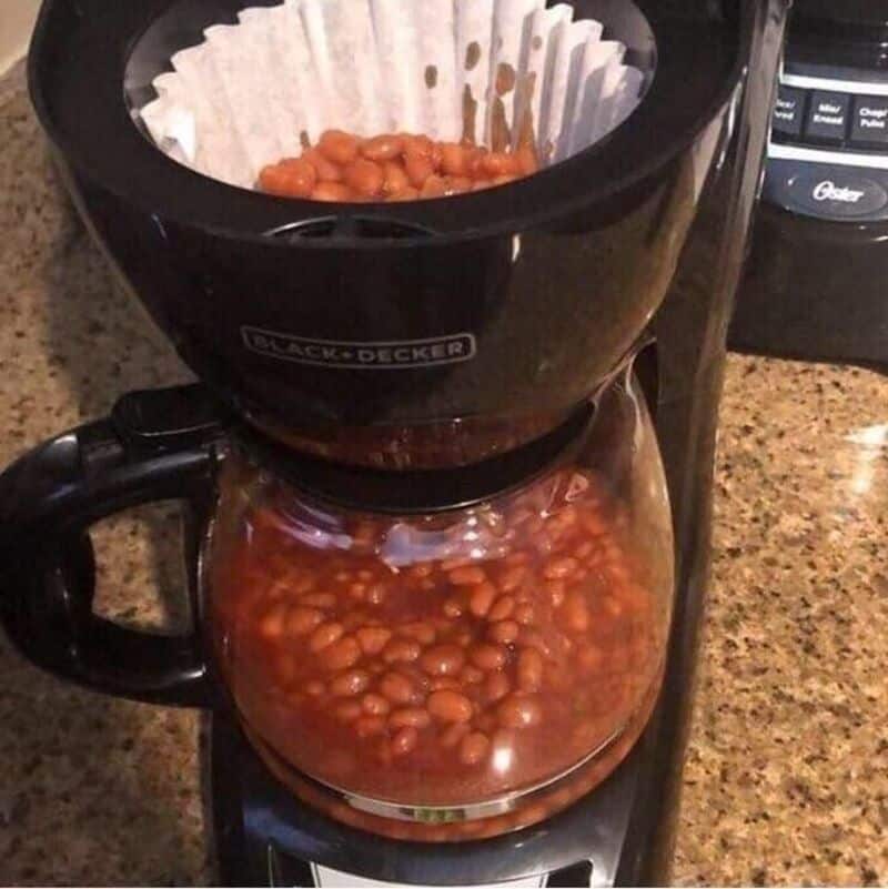 Coffee maker with beans inside, resembling a coffee pot and filter.