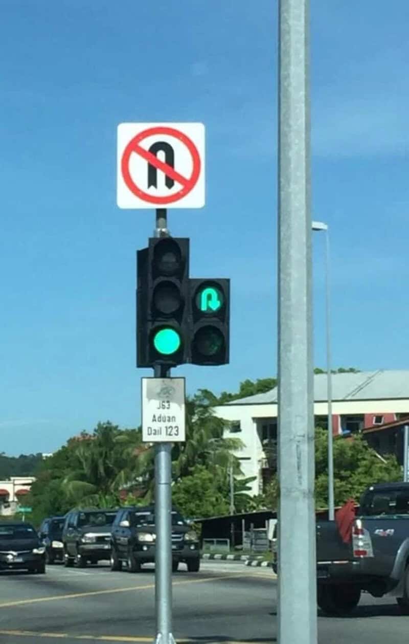 Traffic light showing green arrow for straight and right turn, no U-turn sign above.