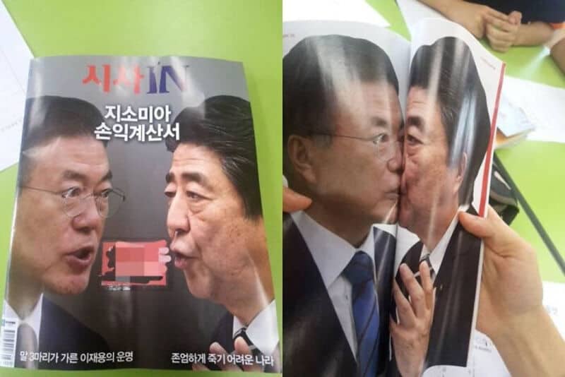 Two men appear to be kissing a photo of each other in a magazine.