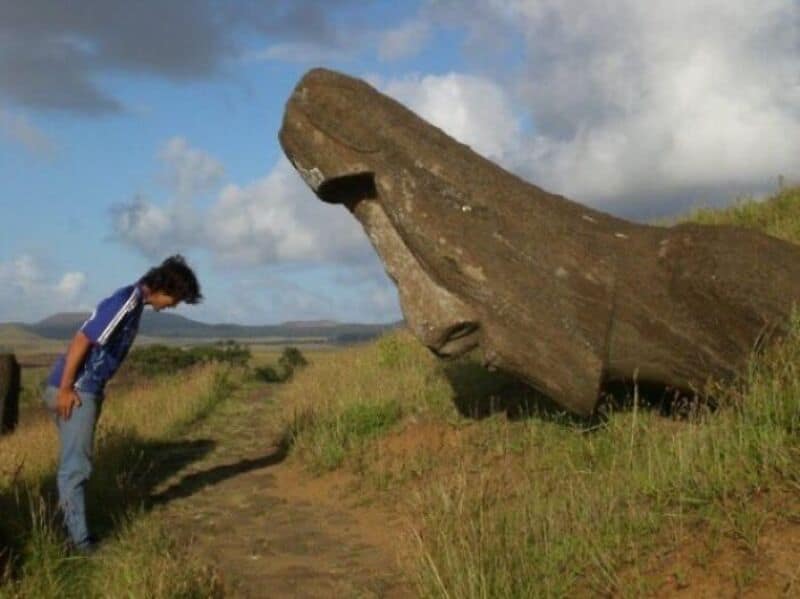 Person looking at a large Moai statue on Easter Island.