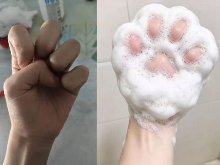 Fist with fingers curled, next to a foamy soap with pink paw print design.