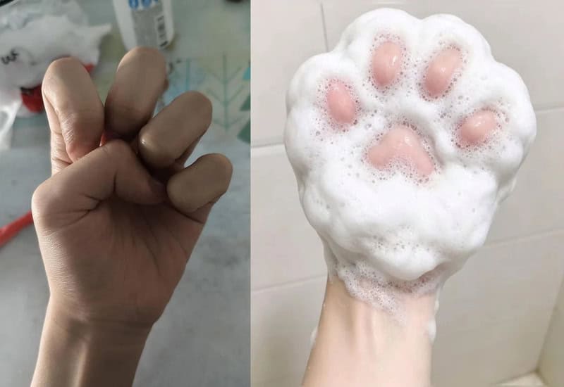 Fist with fingers curled, next to a foamy soap with pink paw print design.