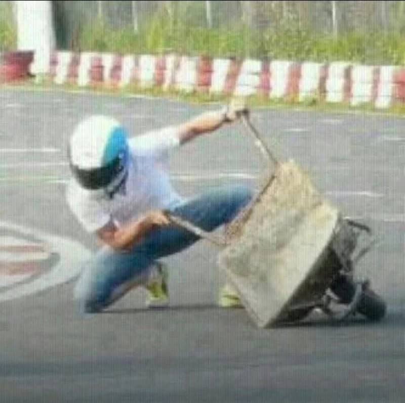 Person falling with a shopping cart on a street, helmet on, in a humorous accident.