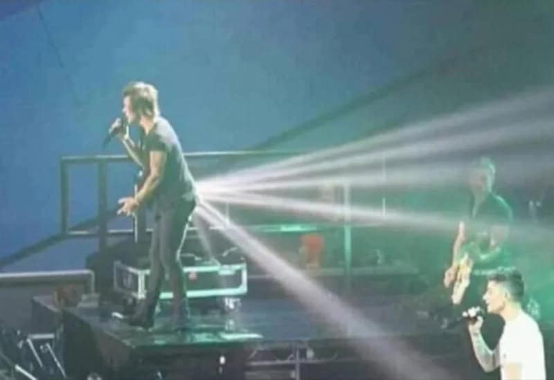 Musicians perform on stage with bright stage lights and fog effects.