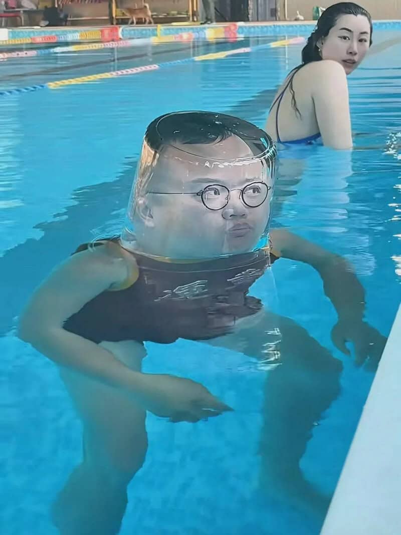Child with glasses and a helmet in a swimming pool, woman in background.