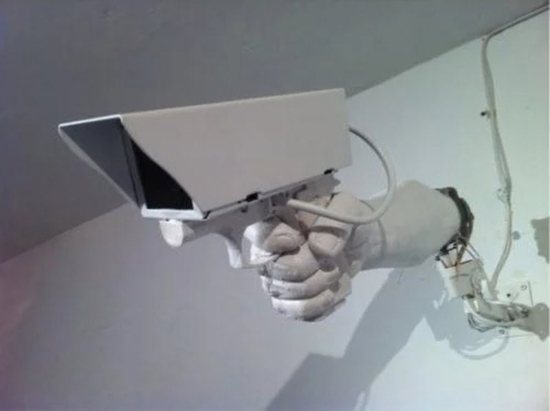 Security camera mounted on the wall, pointing downward.