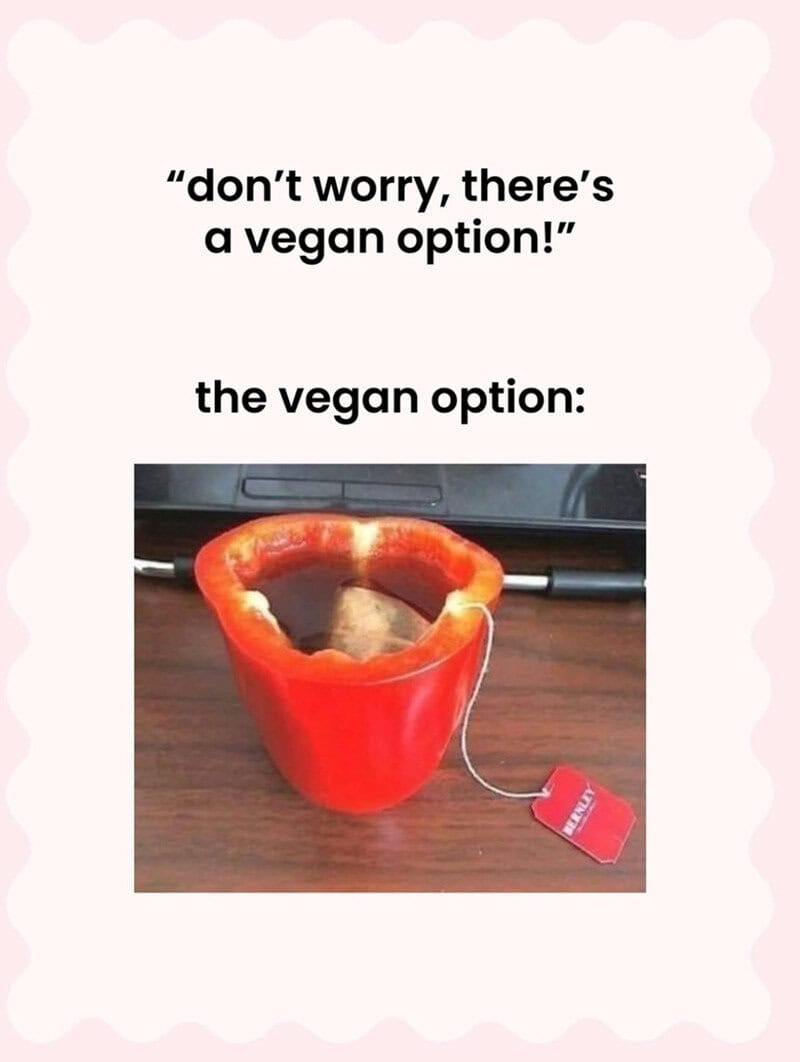 A red bell pepper with a tea bag inside, on a wooden surface.