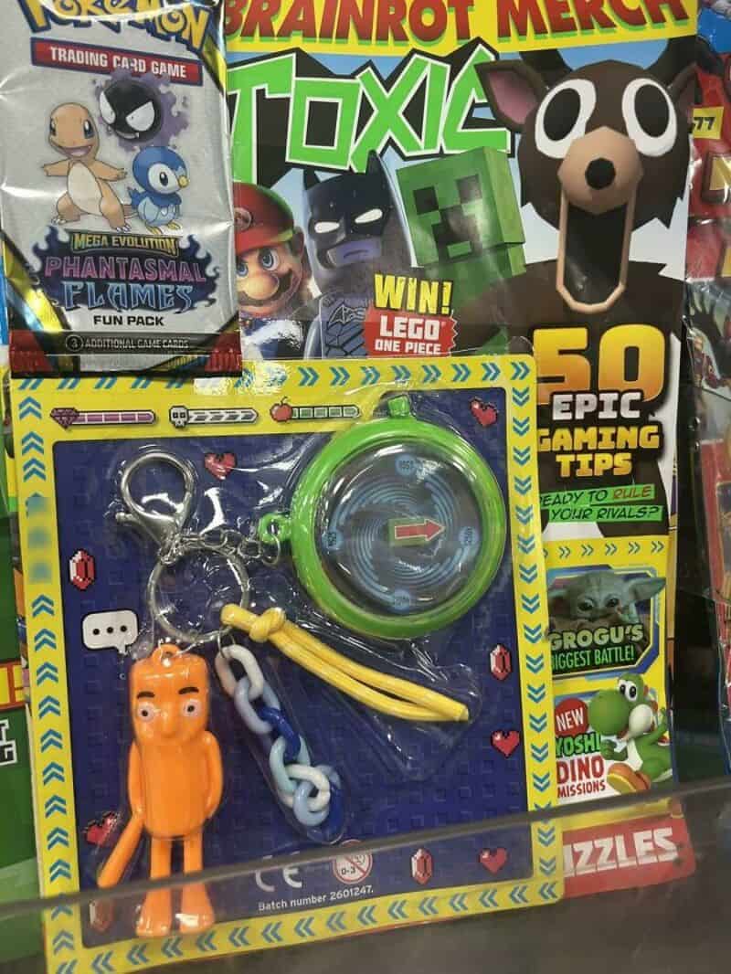 Toxic Brainrot Merck magazine cover with dog toy and keychain in front.
