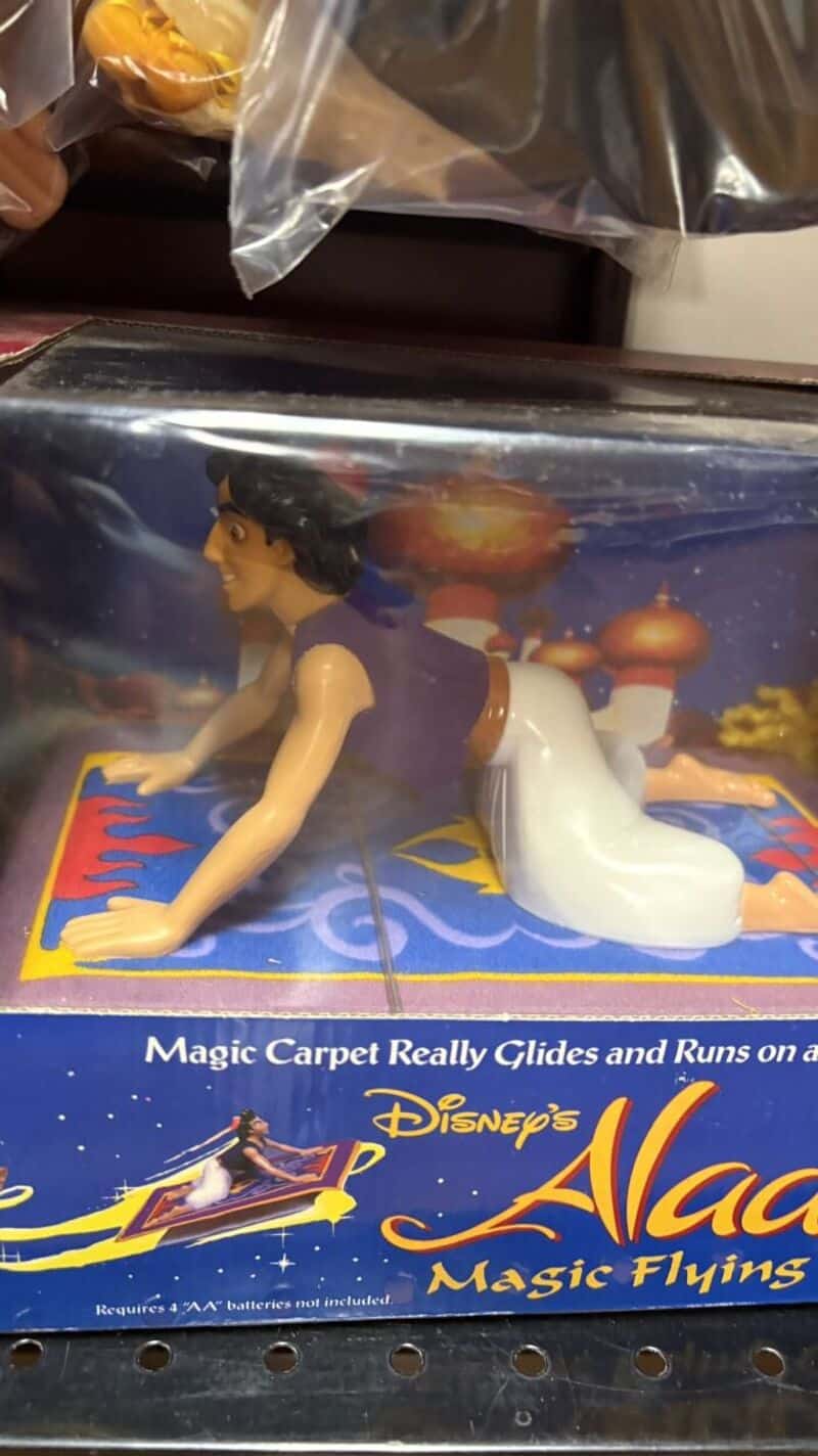 A plastic Aladdin figurine on a magic carpet toy box.