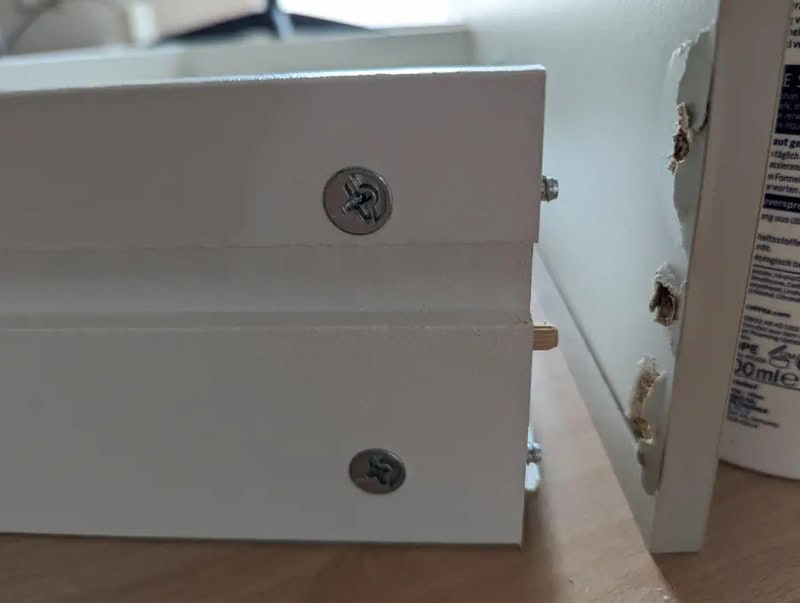 Furniture assembly fails: drawer misaligned and screws not properly fixed.
