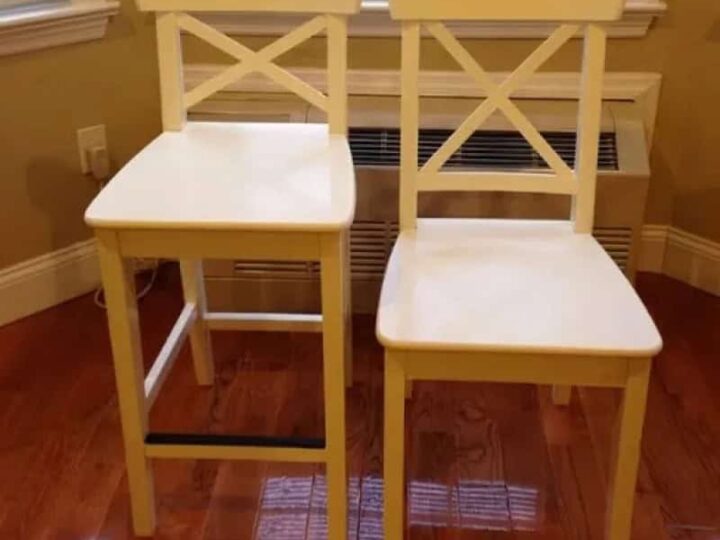 Two yellow chairs with mismatched seat heights in a room with hardwood floor.