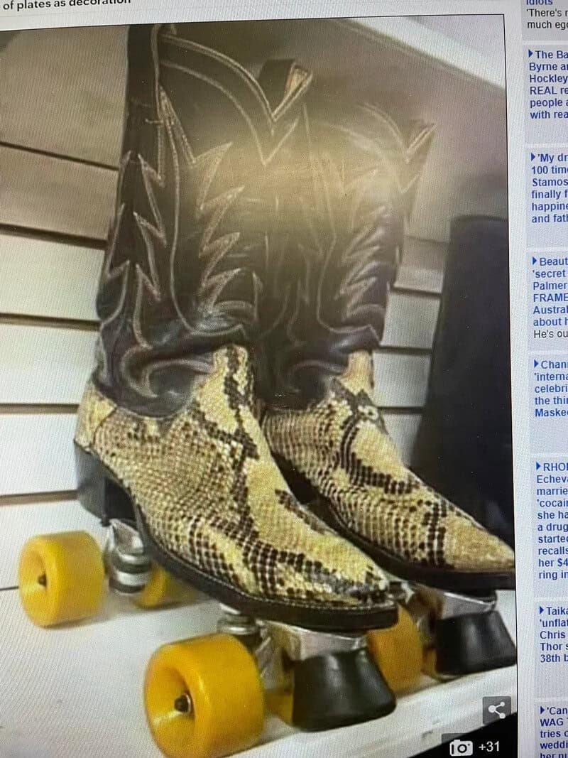 Pair of cowboy boots on roller skates with yellow wheels.