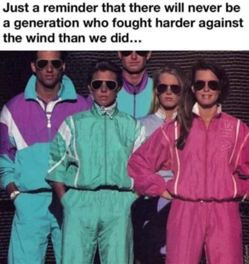Group of five people in 80s/90s style colorful windbreakers and sunglasses.