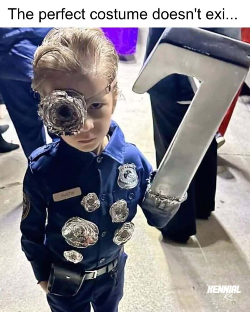 Child in police uniform with a makeshift eye patch and a large metal object on the face.