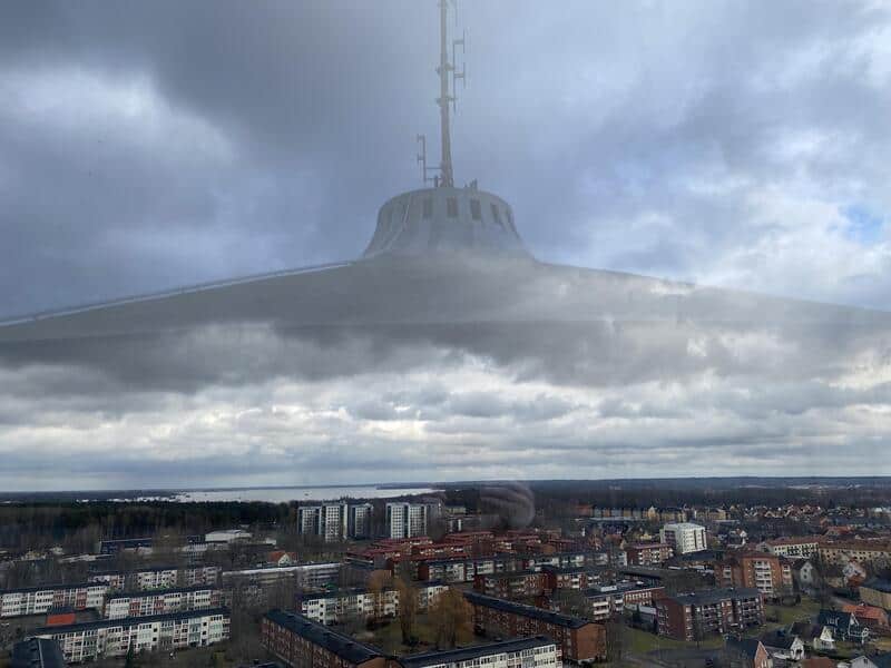 UFO-shaped cloud over a city with buildings and a cloudy sky.