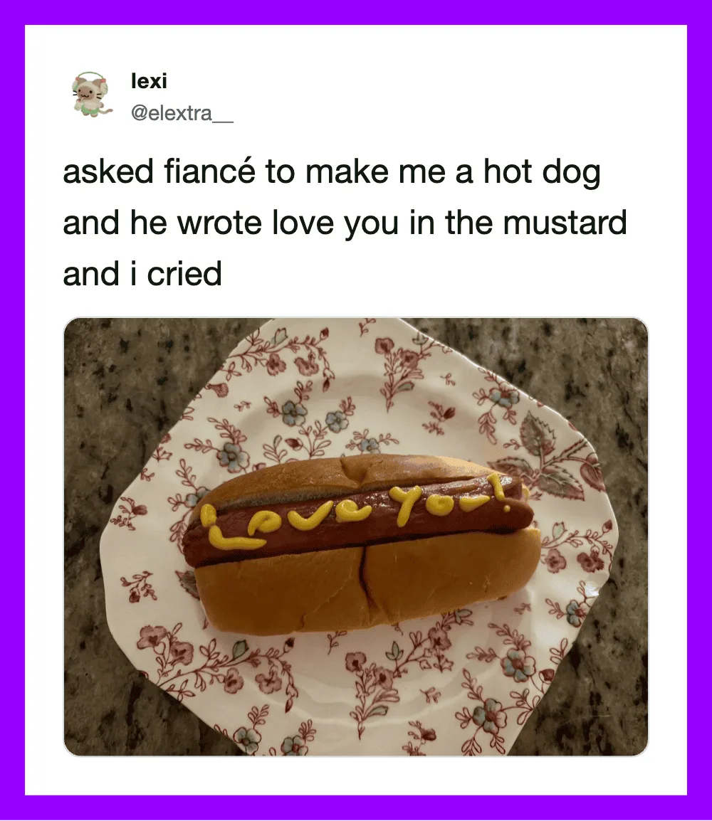 Hot dog with mustard and 'Love You' written on it, on a floral paper plate.