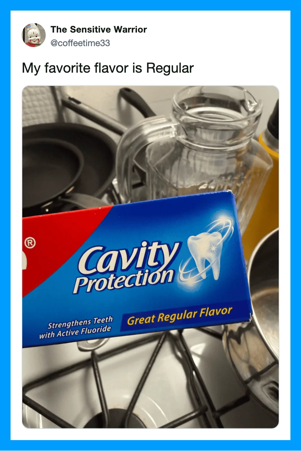 A box of Cavity Protection toothpaste with a glass pitcher and kitchen utensils in the background.