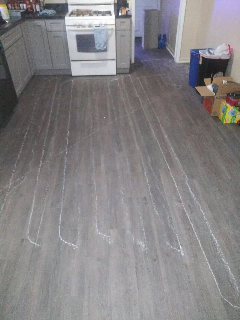 Kitchen with white stove and chalk lines on the floor for a project.