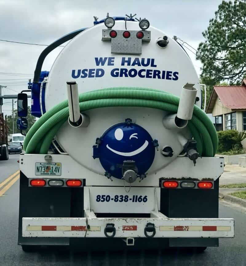We haul used groceries sign on the back of a truck with a smiley face.