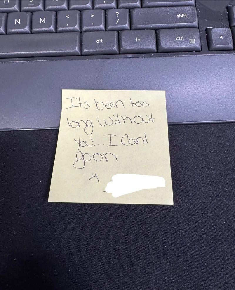 Note on a yellow sticky note on a keyboard: 'Its been too long without you. I can’t go on'.