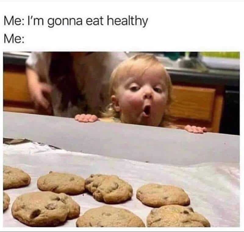 Cookies on a baking sheet with a surprised child peeking over the counter.
