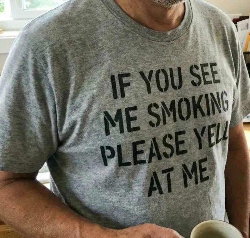 Man wearing a gray T-shirt with humorous text about smoking and yelling.
